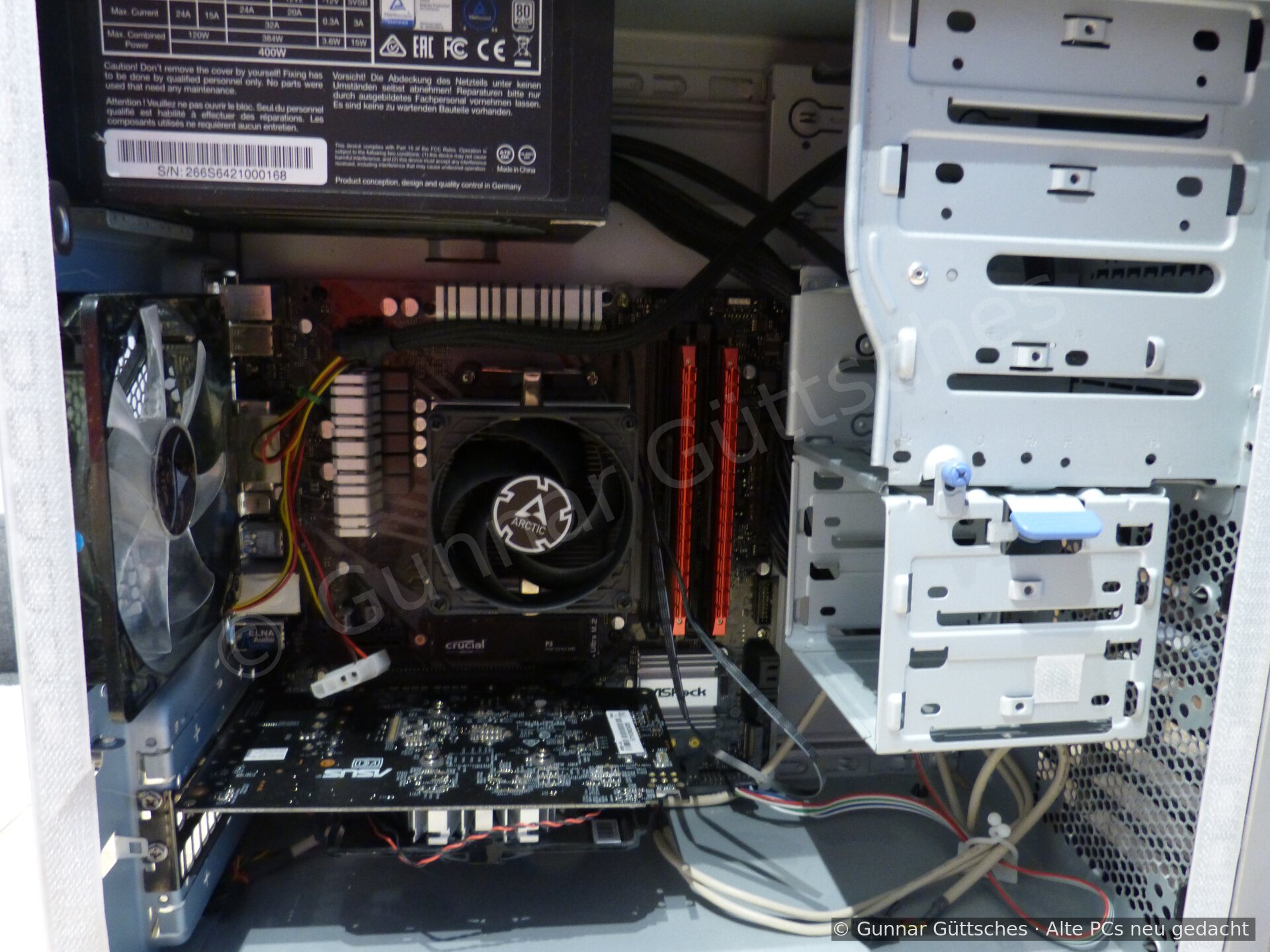 Geöffneter ASRock-Rechner mit Ryzen-Kühler, zwei RAM-Modulen, Grafikkarte und be-quiet-Netzteil